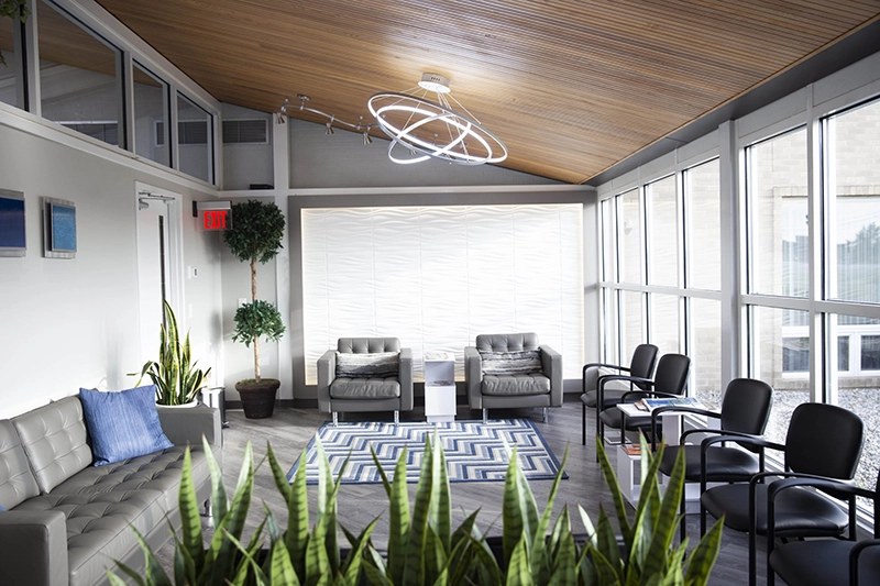 Dental Innovations patient waiting area. Walls and windows lined with chairs.