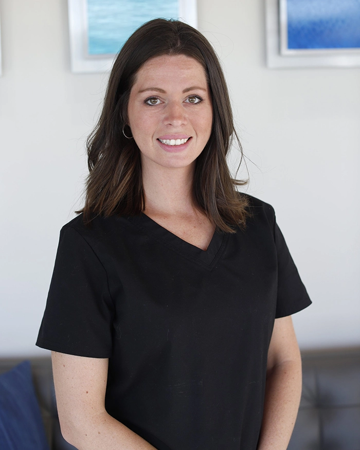 Portrait of Valenscia from the waist up. Woman in black uniform with brown hair.