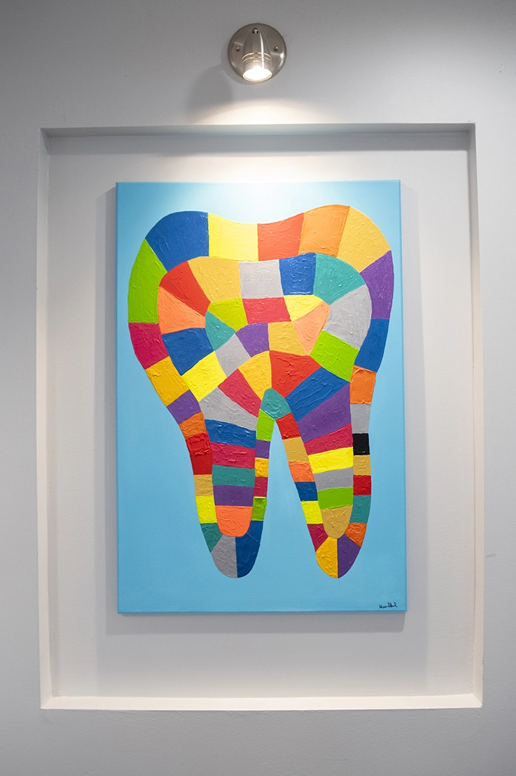 Abstract art piece of a multi-colored tooth on a light blue background.