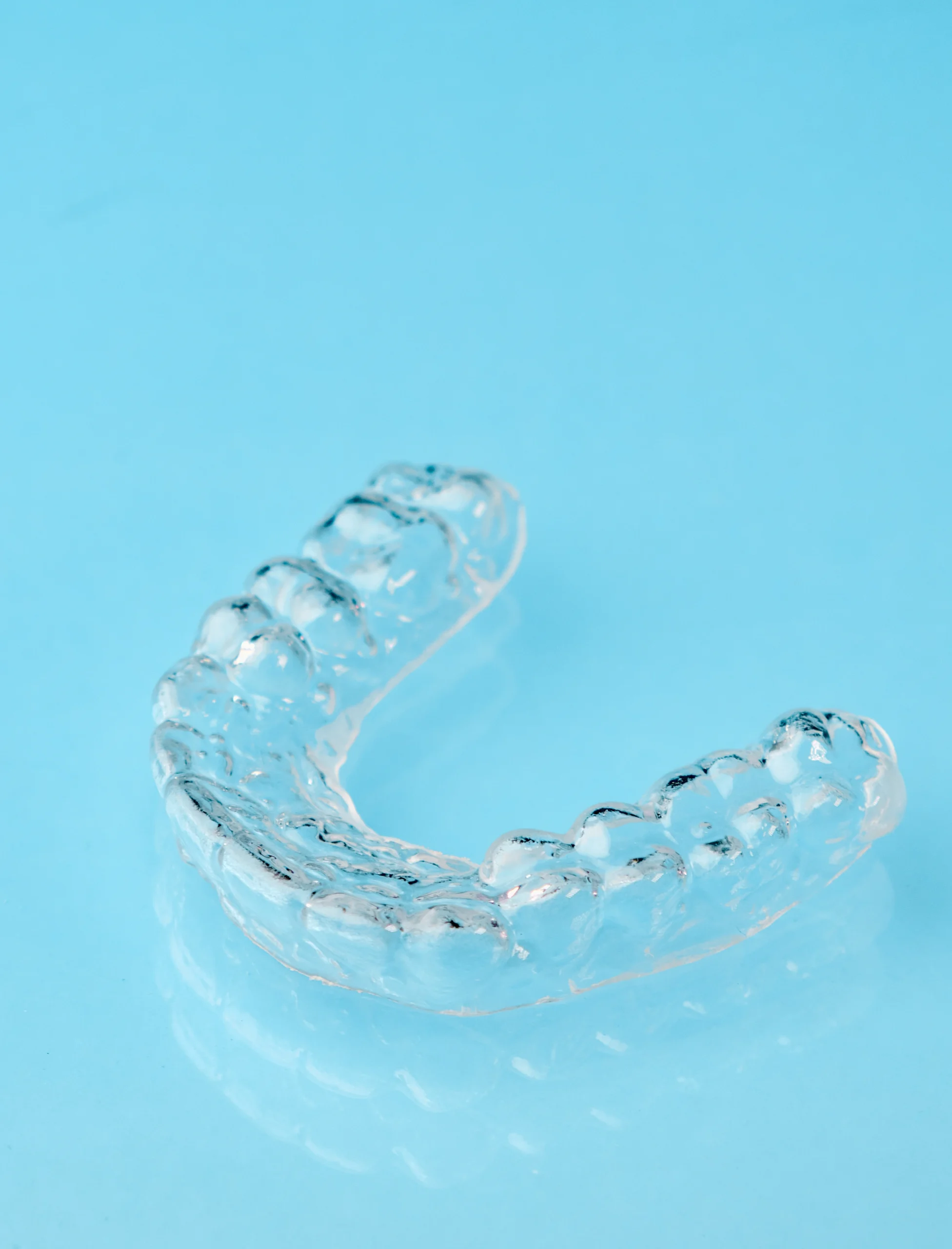 Clear mouth guard on a blue background.