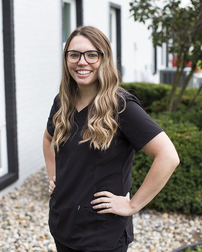 Portrait of Brittney, Business Team Member from the waist up. Woman in scrubs uniform.