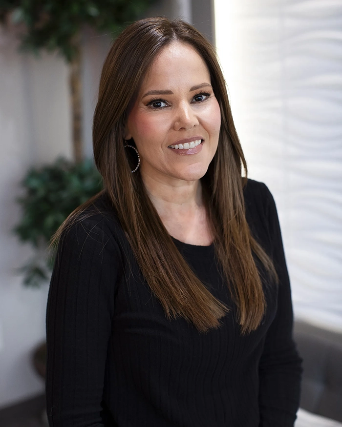 Portrait of Tara, Business Team Member from the waist up. Woman in black uniform with brown hair.