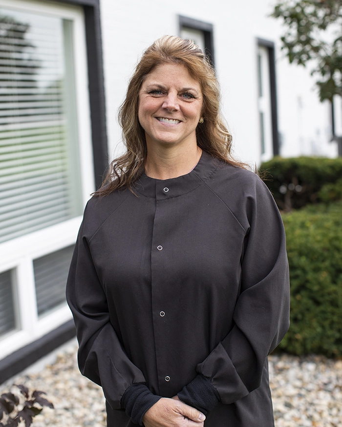 Portrait of Tina, Dental Hygienist from the waist up. Woman in hygienist uniform with brown hair.