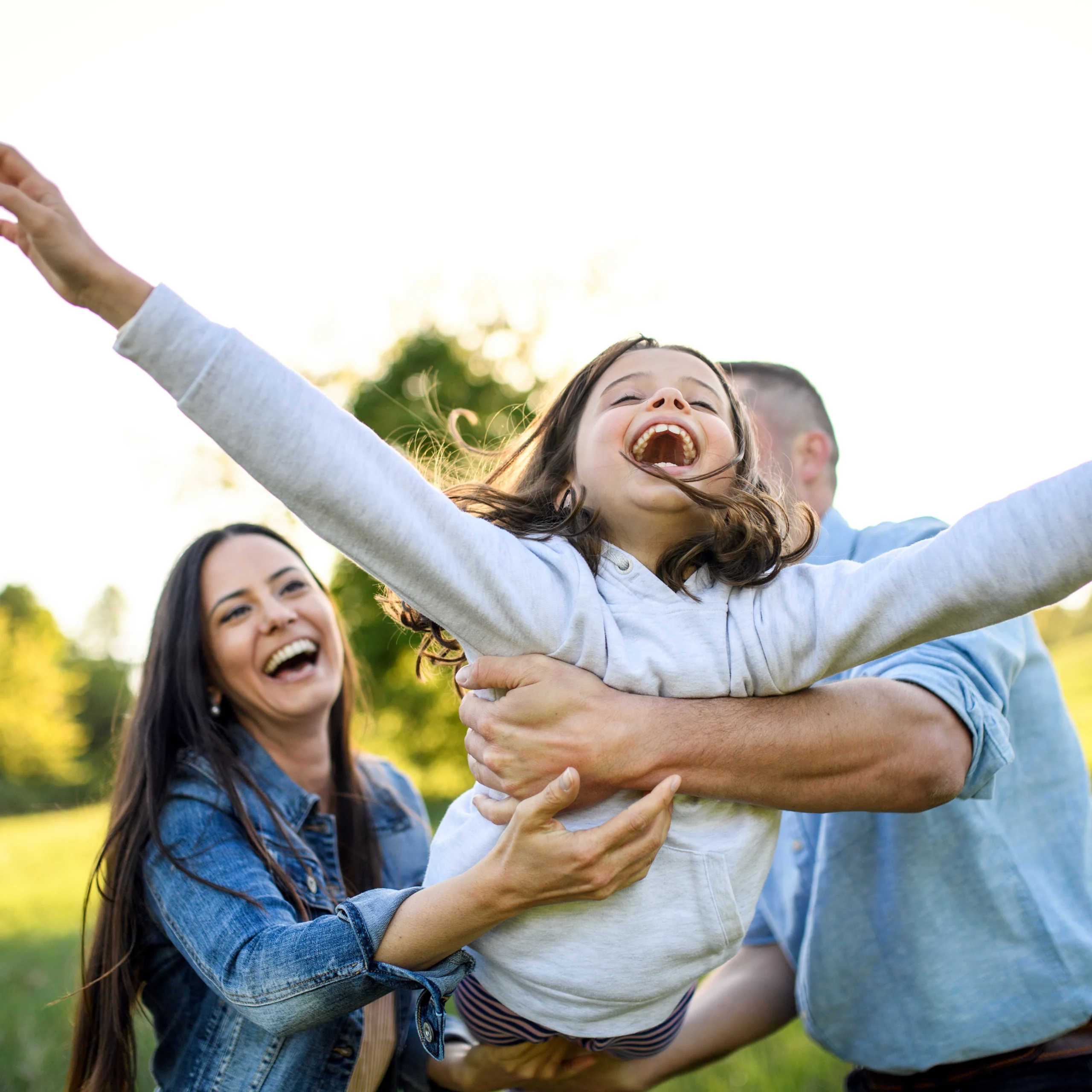 Family Dentist Perrysburg Parents playing with daughter outside.
